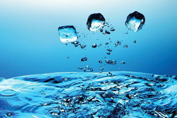 Pieces of ice and drops on a blue background