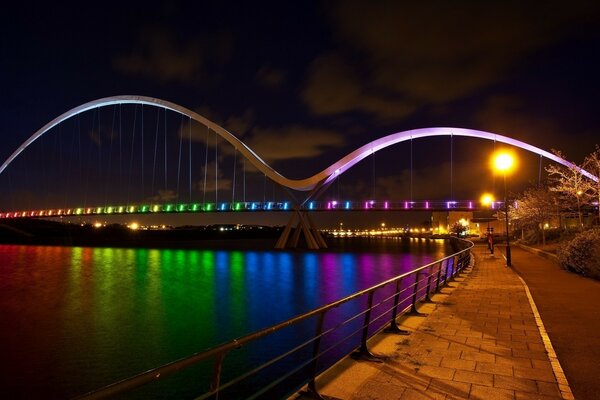 Regenbogenlichter auf der Brücke über den Fluss