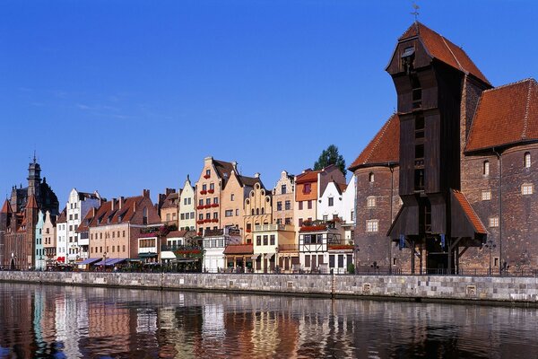 Ville se reflétant dans la rivière sur fond de ciel bleu