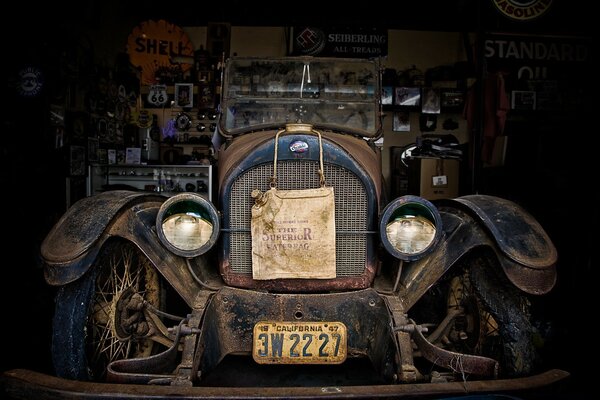 An old car in a shed with a front view