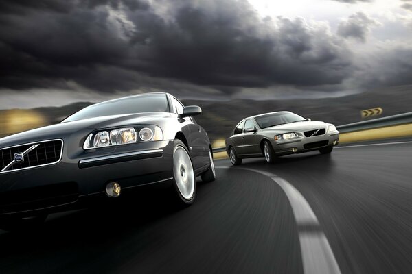 Two Volvos overtaking on the highway, cars under cloudy skies