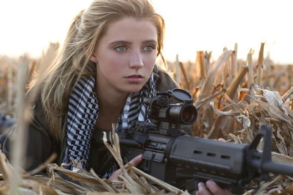 Blonde Mädchen mit einem Maschinengewehr in den Händen