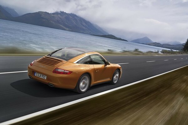 Orange car on the background of mountains and the sea