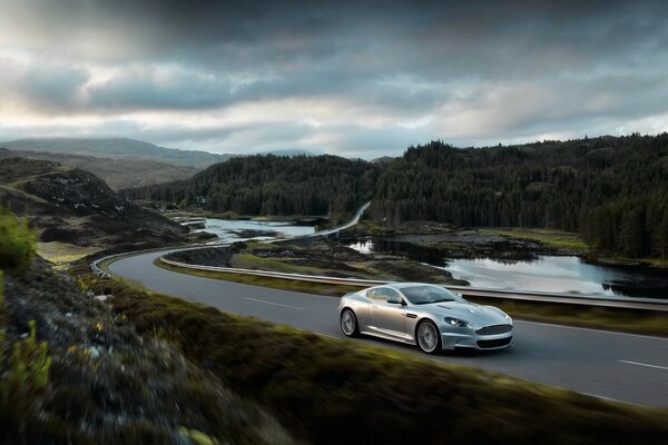 Un Aston Martin argenté se précipite sur la route