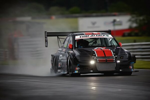 Black mitsubishi car racing on the race track