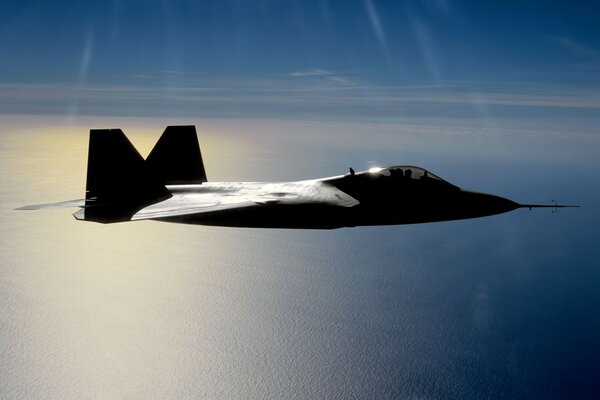 Fighter plane in the sky over the ocean