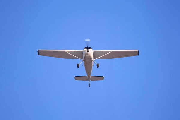 A small passenger plane on a blue sky background