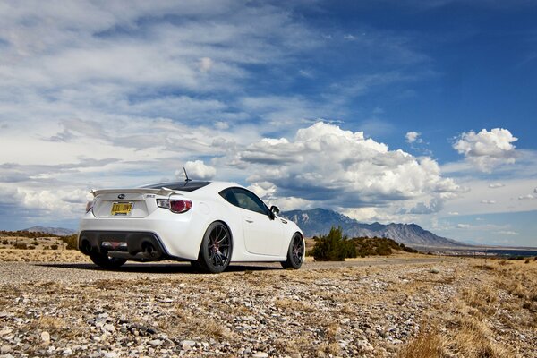 White subaru against the sky and clouds