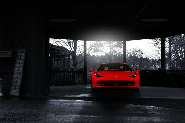 Una ferrari rossa brillante al centro di una foto in bianco e nero