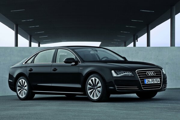 Schwarze Audi a8 Limousine auf Betonwand Hintergrund