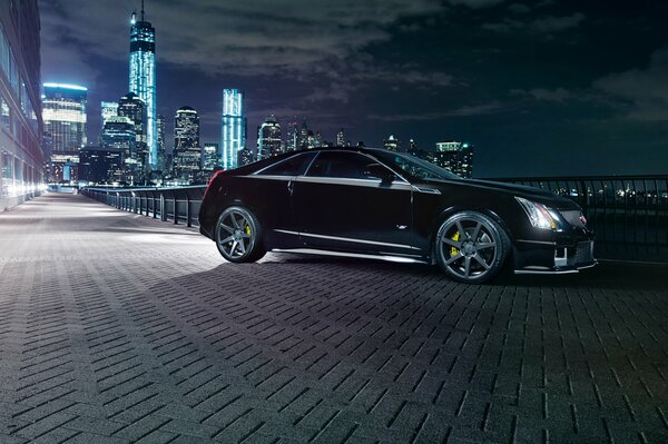 Cadillac noire dans les lumières de la ville de nuit