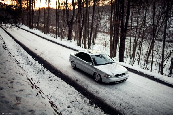 Audi A4 en un camino nevado en medio del bosque