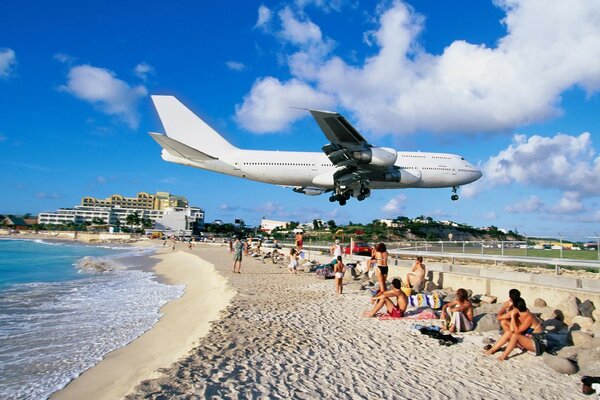 Avión sobrevuela playa con gente