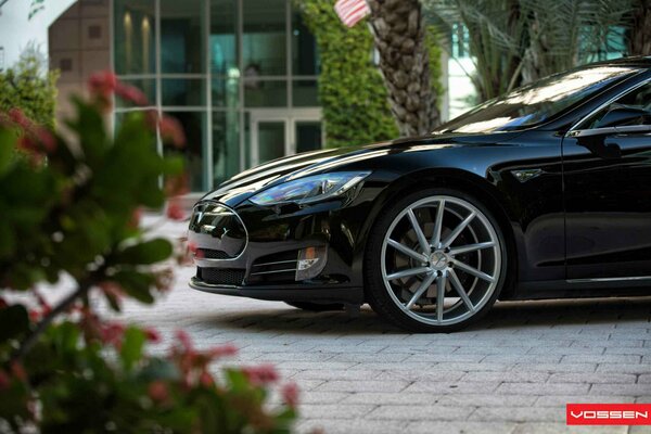 Tesla model S on the background of the facade of the building