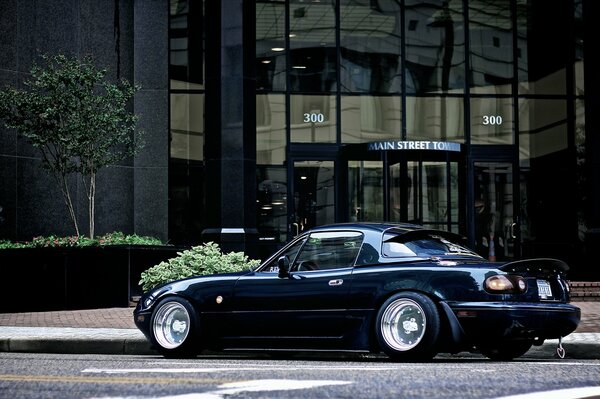 Dark blue mazda coupe in urban conditions