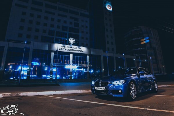 A blue car on the background of a blue night building