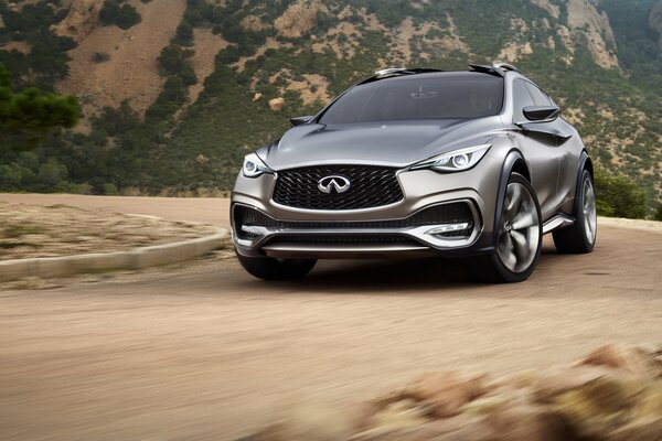 Автомобиль infiniti qx30 на дороге в горах