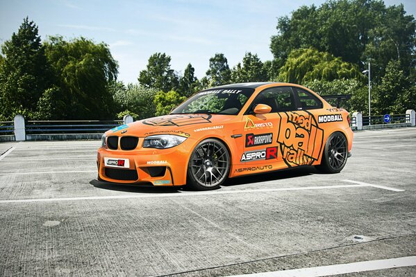 Voiture orange sur fond d arbres verts