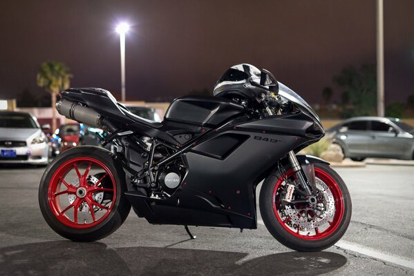 Moto ducati noire dans le stationnement de nuit