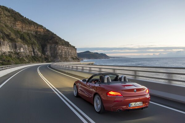 Hermoso convertible de color rojo en el fondo de un paisaje fresco