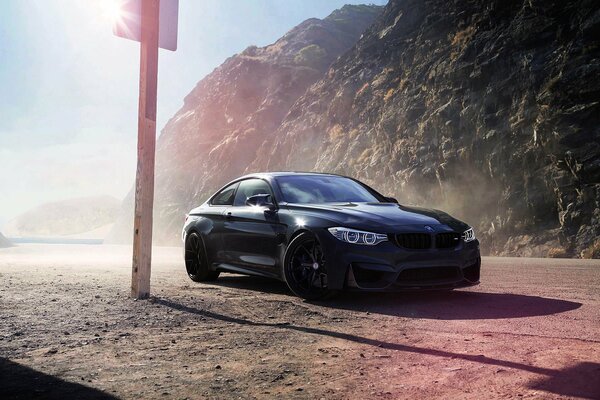 Bmw M4 negro en una plataforma bañada por el sol