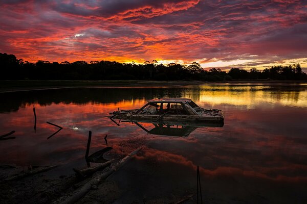 Ertrunkenes Auto im See bei Sonnenuntergang