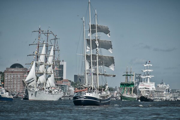 Schiffe und Segelboote bei einer Parade in Hamburg an der Elbe