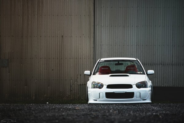 Subaru Impreza blanco frente a la puerta