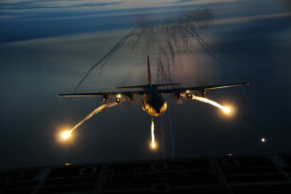 Lumières de nuit de l avion c-130 au-dessus de l aérodrome