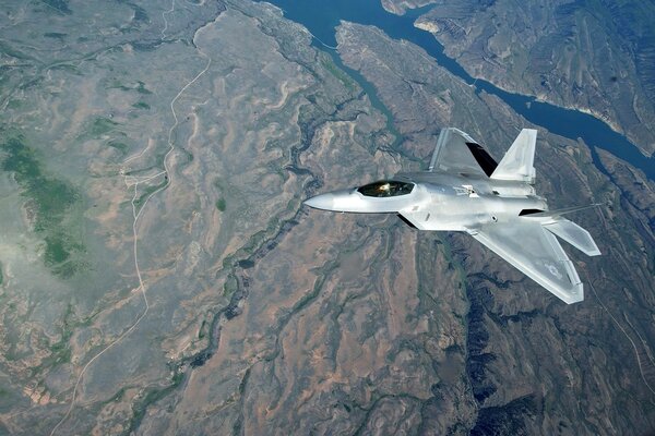 Flugzeug f-22 über der Erdoberfläche