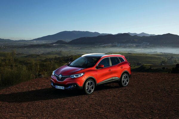 Red Renault on the background of mountains and blue sky