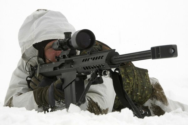 Aiming sniper hiding in the snow-covered ground