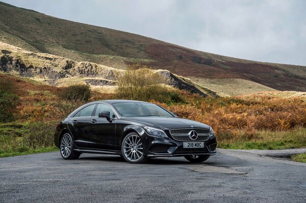 Mercedes noire sur la piste dans les montagnes