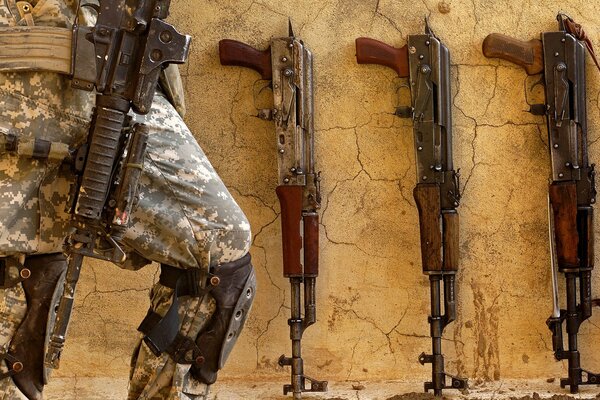 Passage of a man at the wall with machine guns