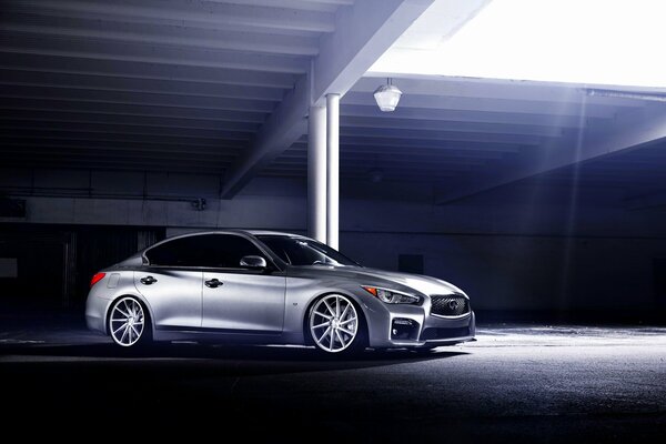 Silver Infinity illuminated by daylight in an underground parking lot