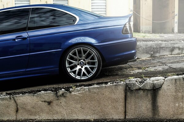 Dark blue BMW on a stone wall background