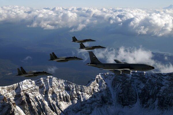 Five combat aircraft hover above the ground