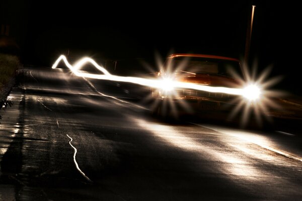 Pista della macchina sulla strada di notte