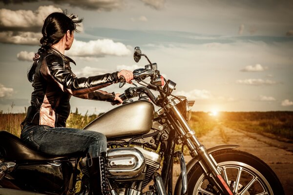 Mädchen auf einem Motorrad im Sonnenuntergang