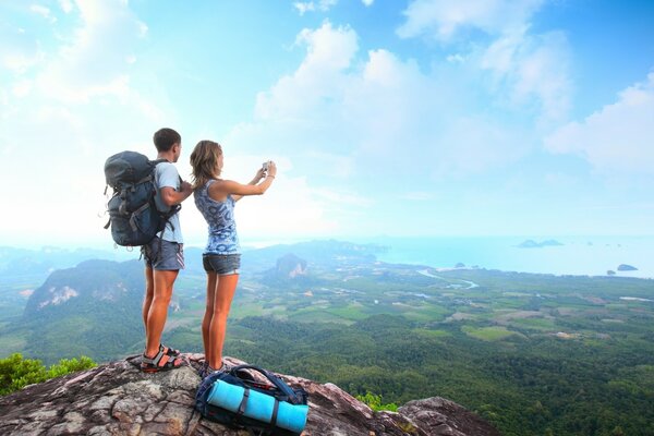 A couple on a cliff near a cliff in a mountainous area