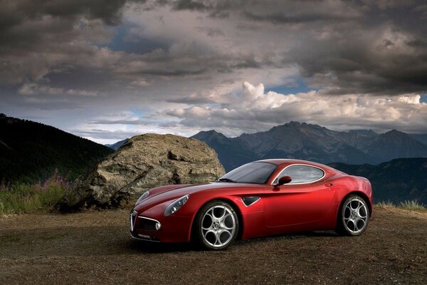 Voiture rouge cool sur la route des nuages et vue sur les montagnes