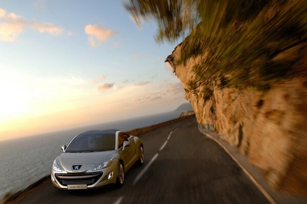 Peugeot Monte sur la route le long de la falaise