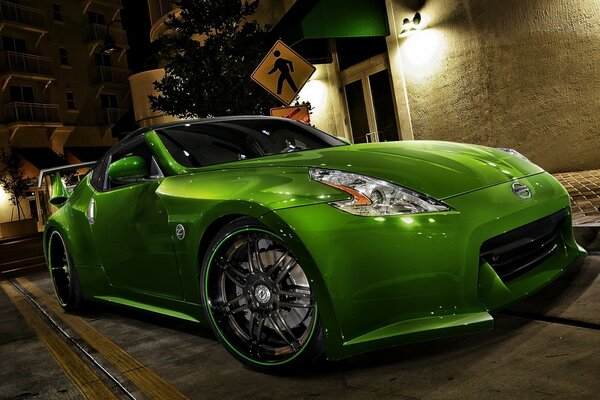 A green tuned car at night at the lantern