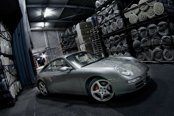 A silver Porsche lurked in the warehouse among the goods