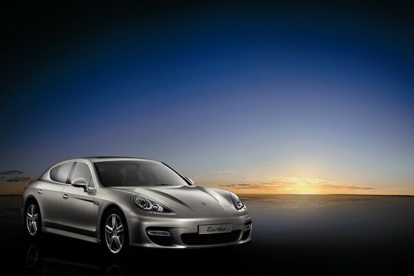 Coche porsche plateado al atardecer