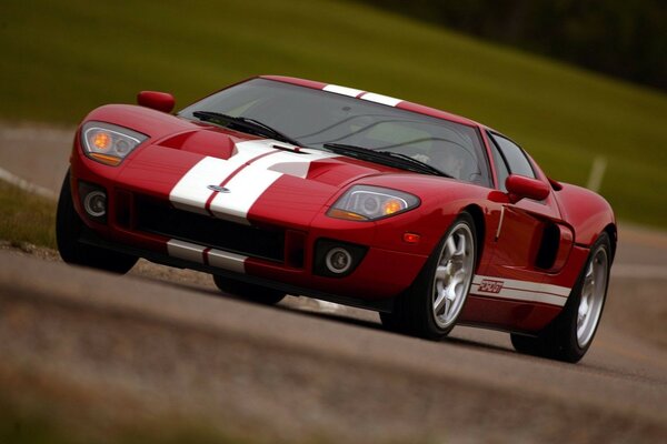 Une Ford GT rouge et blanche passe un tronçon de route