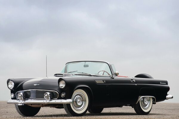 Czarny Ford Thunderbird i szare niebo