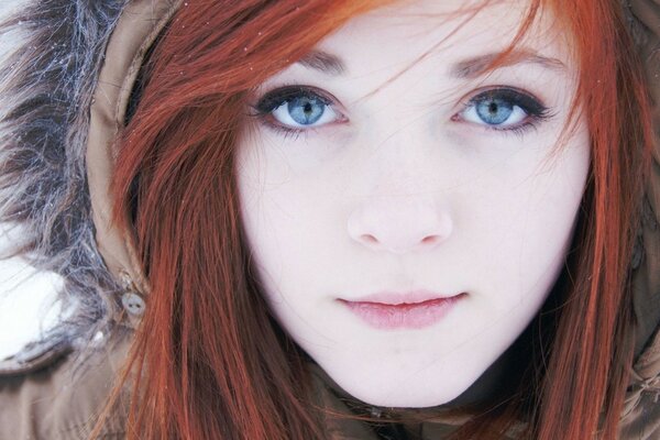 A red-haired girl with gray eyes in a hood