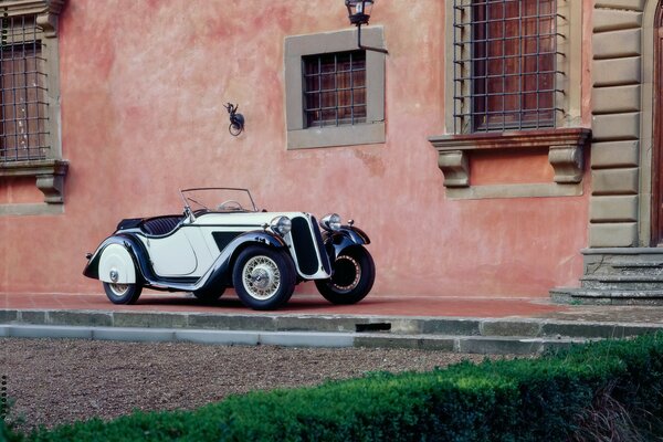 Ein klassischer BMW in der Nähe eines alten Hauses