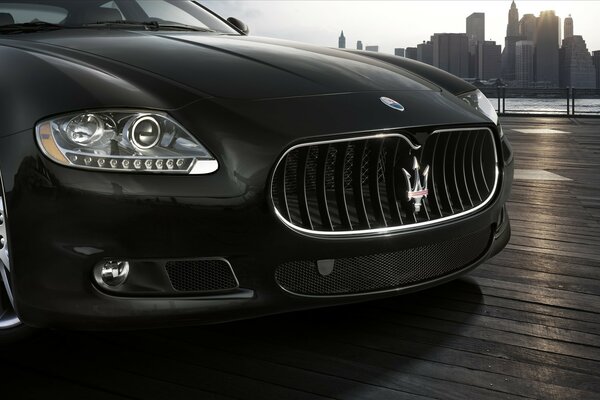 Close-up of a black Maserati on the background of the city